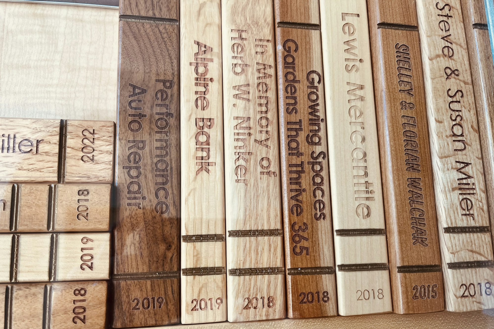 Wooden bricks with engraved names and messages, possibly from a donor recognition display.
