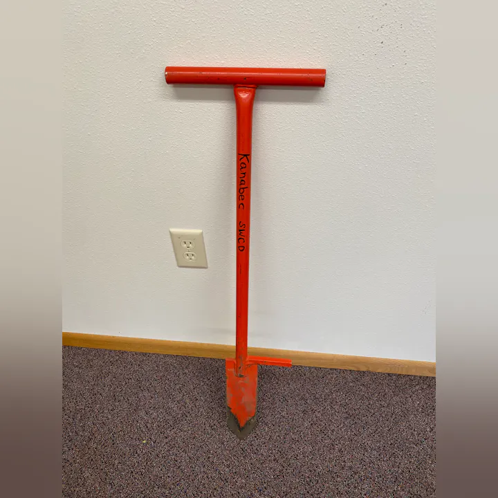 A red tool labeled "Kanabec SWCD" is leaning against a wall.