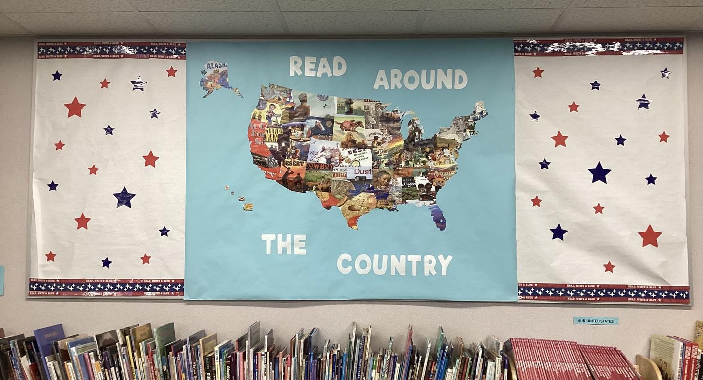 A bulletin board promoting reading across the U.S., featuring a colorful map and star decorations, with books below.