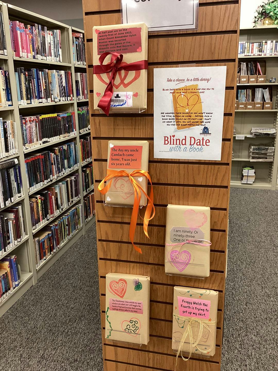 Library display of wrapped books for a "Blind Date with a Book" event, featuring books with intriguing teasers.