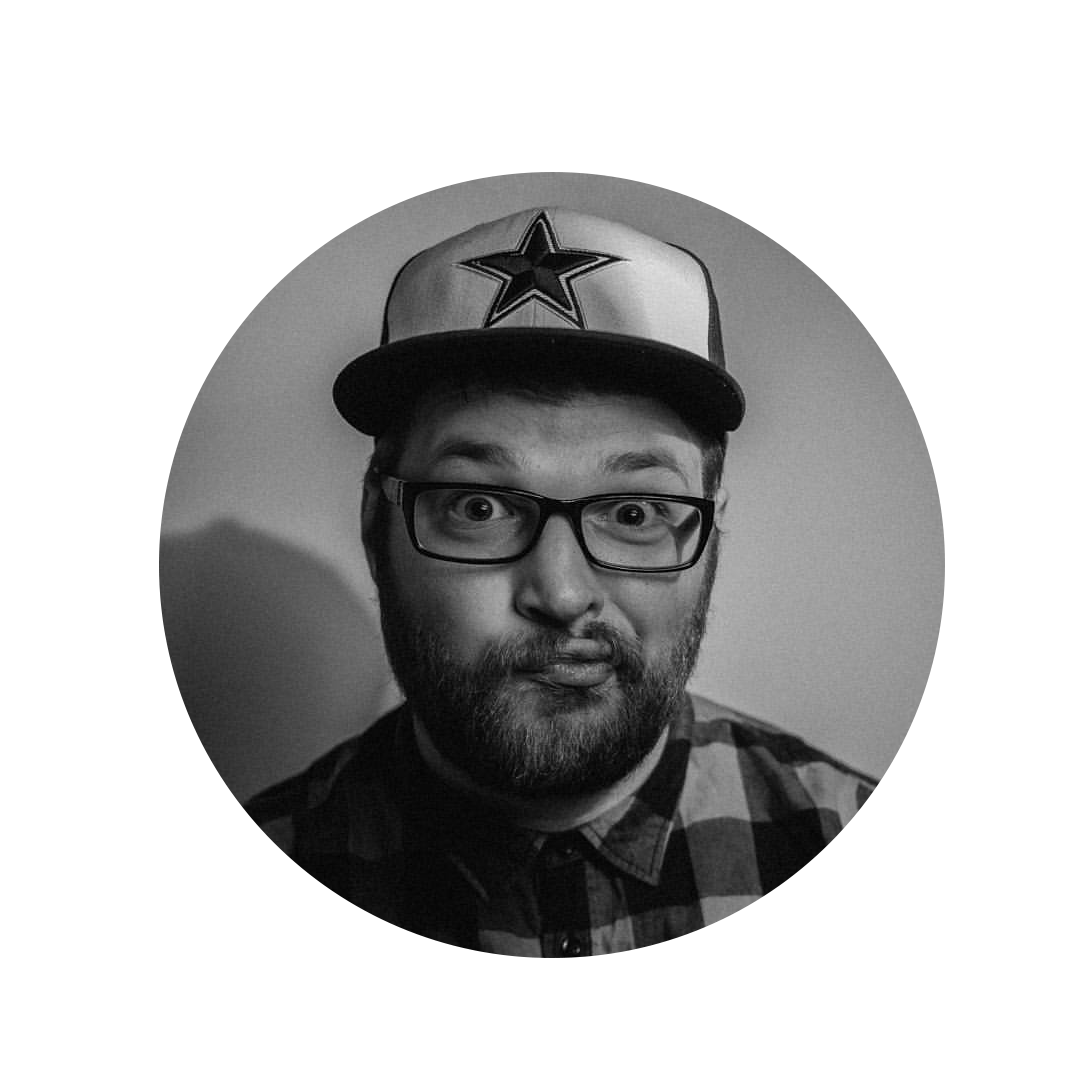 Man with glasses wearing a star cap makes a funny face in a black and white photo.