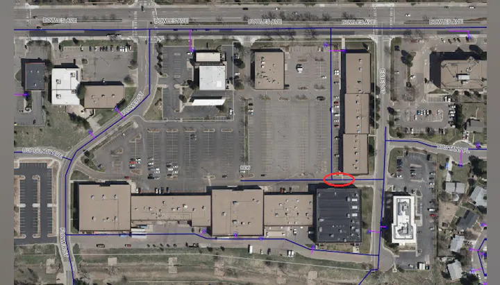 The image is an aerial view of a commercial area showing buildings, parking lots, and streets, marked with paths and labels.