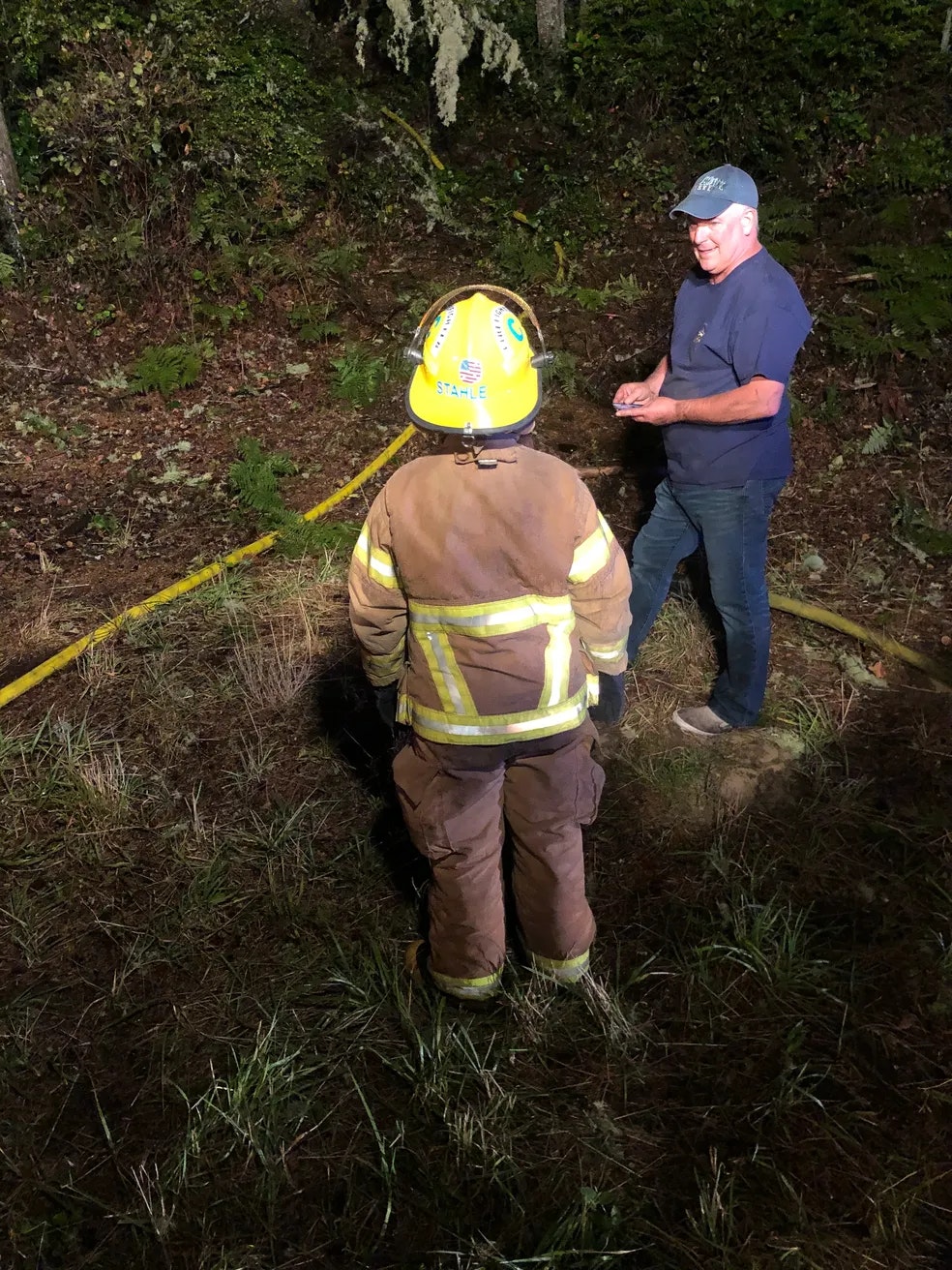 a fire fighter and civilian standing speaking