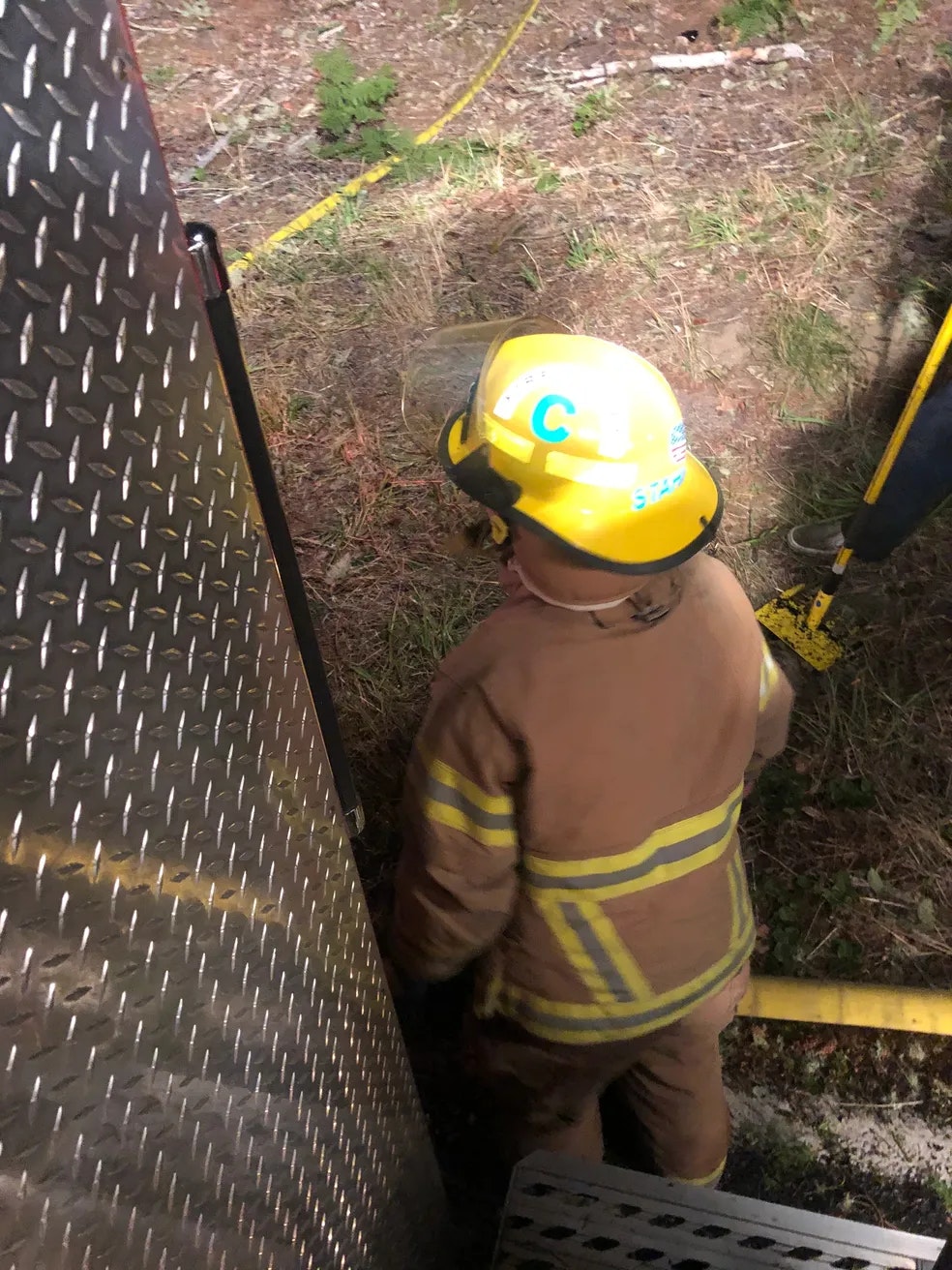 a fire fighter in uniform, angle from above taken from firetruck