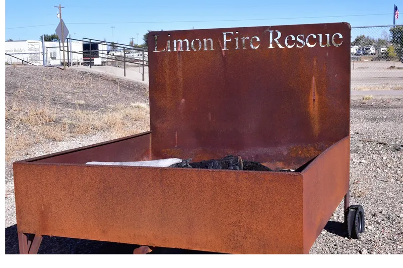 Rusty container with "Limon Fire Rescue" text, likely for training or waste disposal.