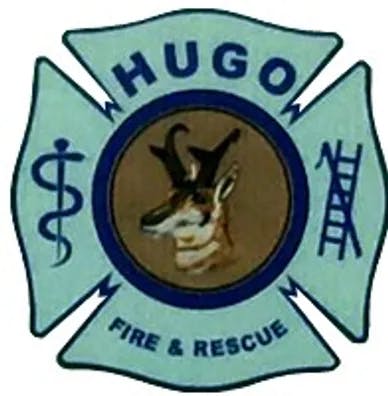 A badge with a dog's image, text "WHUGOW FIRE & RESCUE," and a medical symbol.