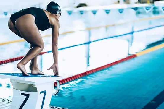 A swimmer preparing to dive into a pool from starting block number seven.
