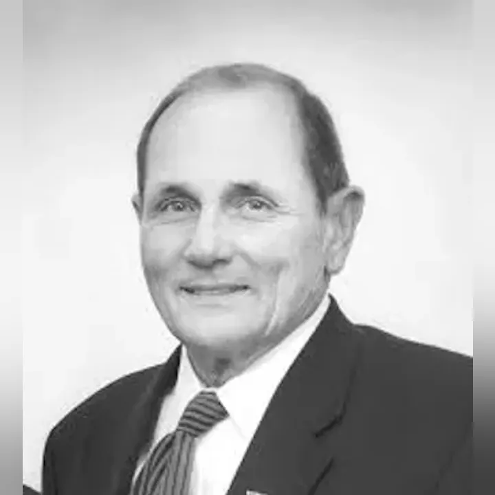 A grayscale portrait of a man in a suit and tie.