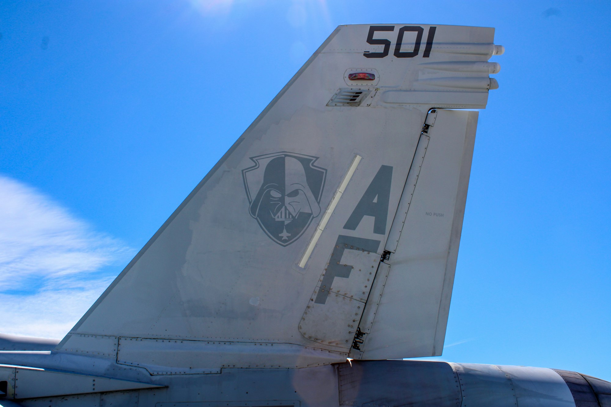 The image shows the tail of a military aircraft featuring a design with a character resembling a prominent figure from science fiction.