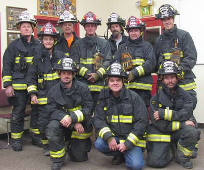 Group of firefighters in uniform posing for a photo.