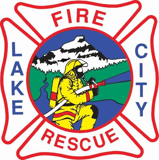 A firefighter emblem with "LAKE CITY FIRE RESCUE" around an image of a firefighter, mountains, and trees.