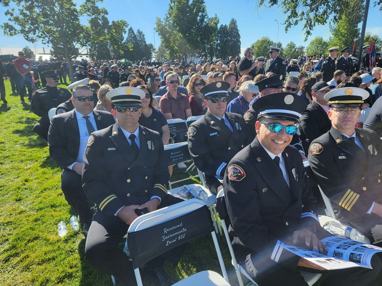 A gathering of uniformed firefighters and attendees, possibly at a ceremonial event.