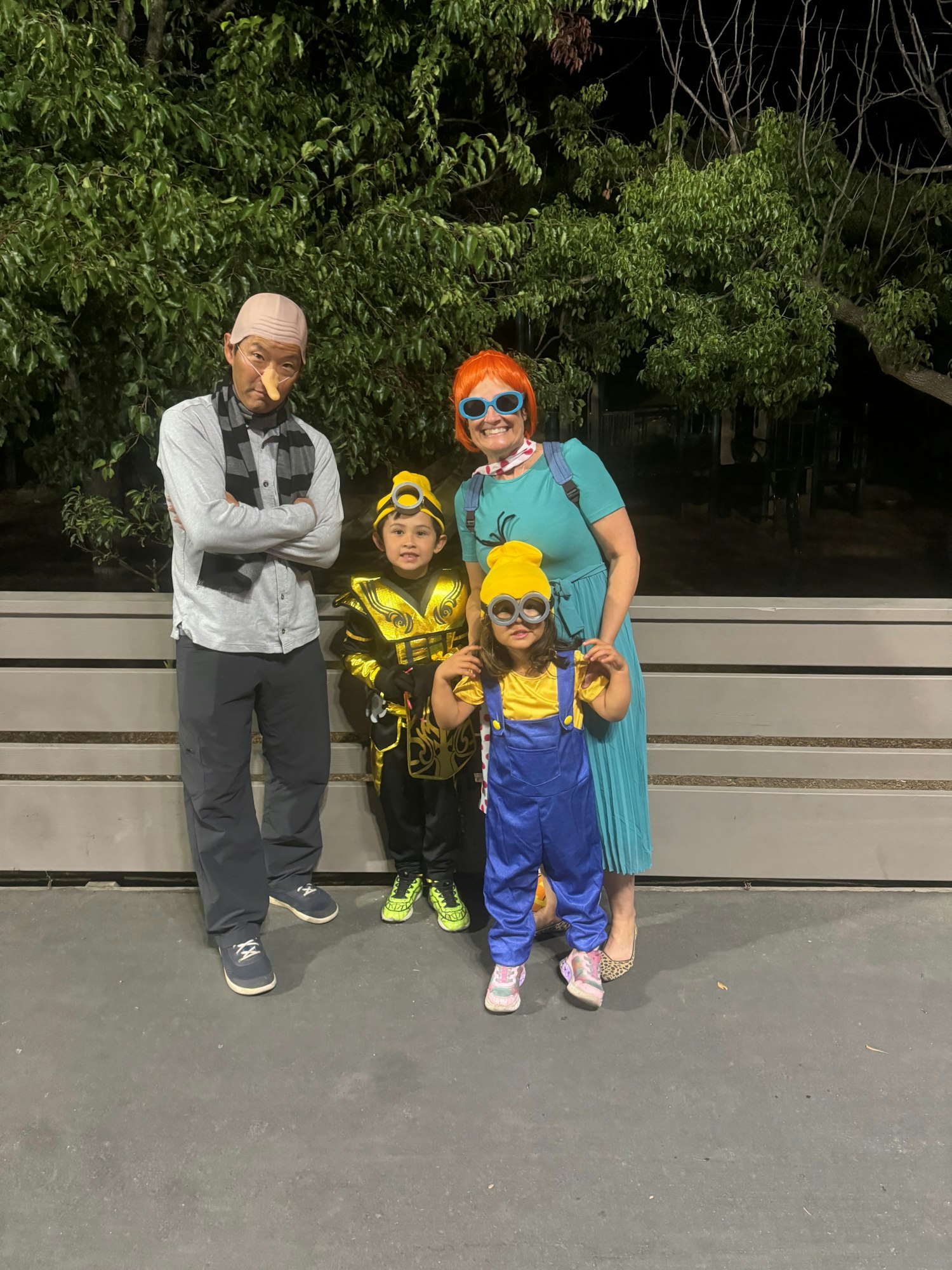 A group in fun costumes, with one looking like an older man, two in yellow and blue, and one with orange hair and blue dress.