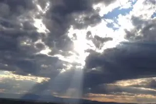 Dramatic clouds with sunlight breaking through, creating rays and a beautiful atmospheric effect.