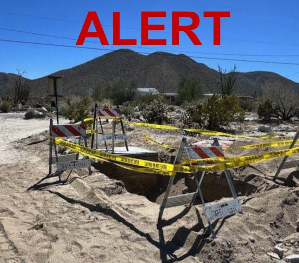 A desert setting with barricade tape around an excavation site and a large "ALERT" text overlay.