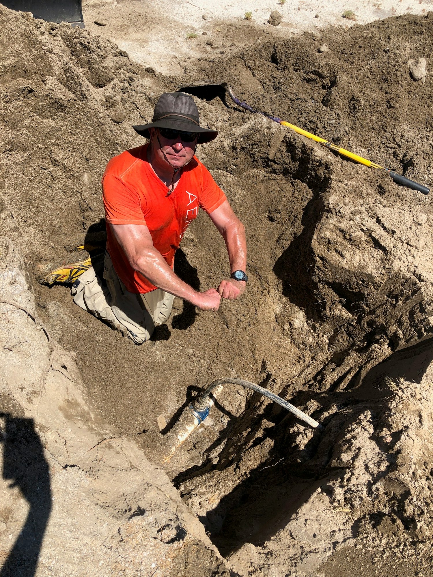 A volunteer performing plumbing in the field.