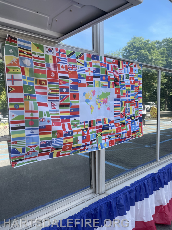 A display featuring various country flags and a map of the world, possibly at a cultural event or festival.