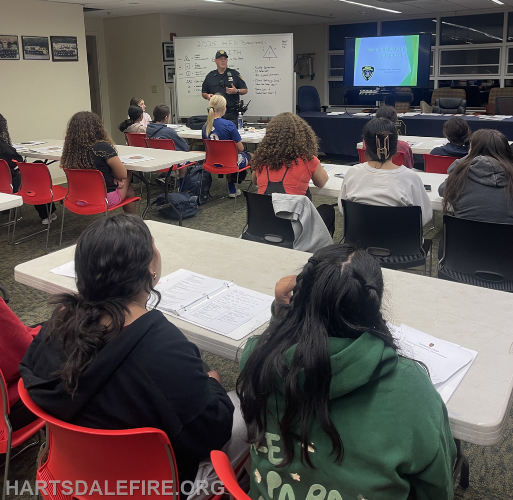 A police officer is teaching a health and safety class to a group of students in a classroom setting.