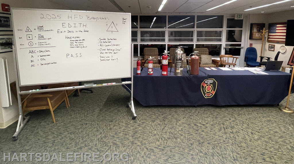 The image shows a fire safety display with a whiteboard detailing E.D.I.T.H. (Exit Drills In The Home) and fire extinguisher instructions.