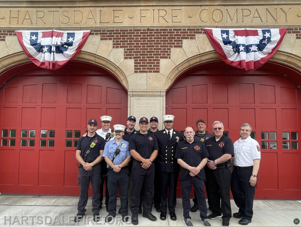 A group of firefighters posing in front of the Hartsdale Fire Company station, with festive decorations above.