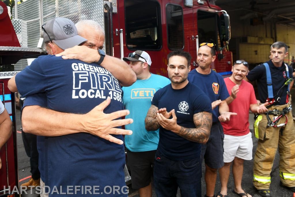 A group of firefighters embraces and celebrates together, showcasing camaraderie and support among their ranks.