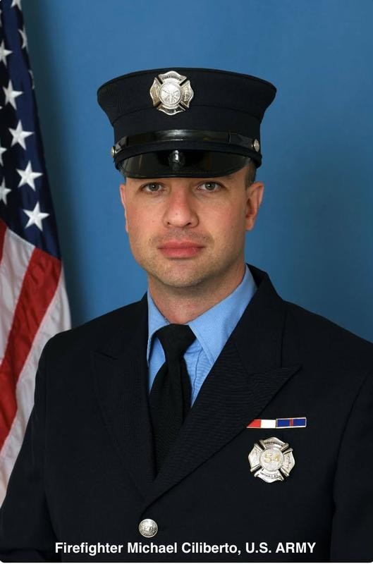 The image features a male firefighter in uniform, with an American flag in the background. He has decorations on his uniform.