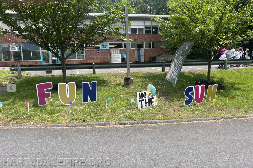 A colorful display with letters spelling "FUN IN THE SUN" near a building, suggesting a cheerful outdoor event.