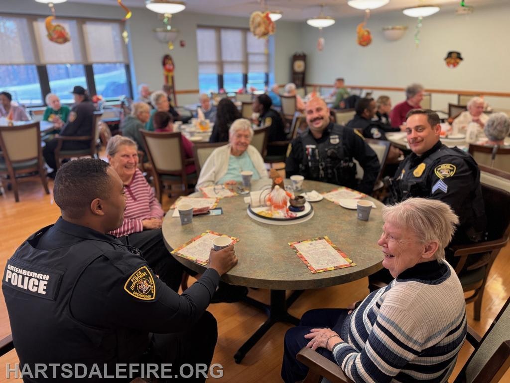 Police officers and seniors enjoy a social gathering at a community dining event, sharing smiles and conversations.