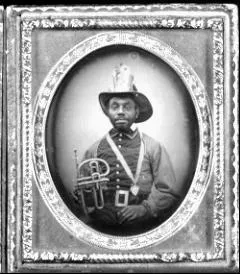 A man in a uniform and decorative hat holding a musical instrument, likely a cornet, framed in an ornate border.