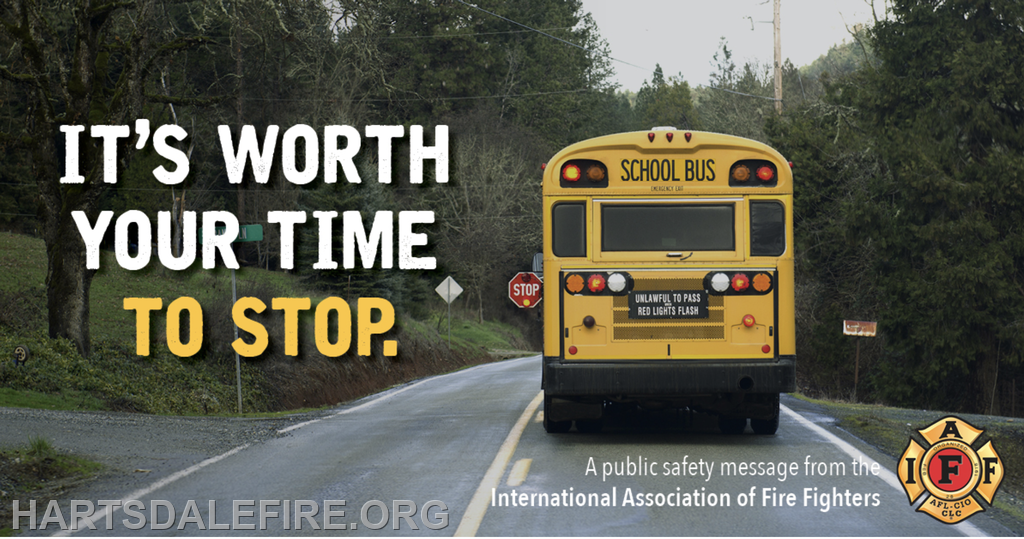 A school bus with a stop sign and caption "It's worth your time to stop." Safety message by International Association of Fire Fighters.