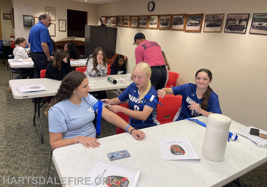 A group of young people is participating in a hands-on training session, possibly related to first aid or emergency services.