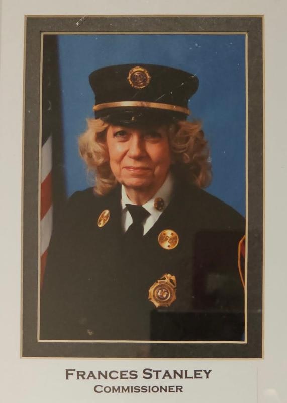 The image features a portrait of a woman in a uniform with badges and a hat, labeled "Frances Stanley, Commissioner."