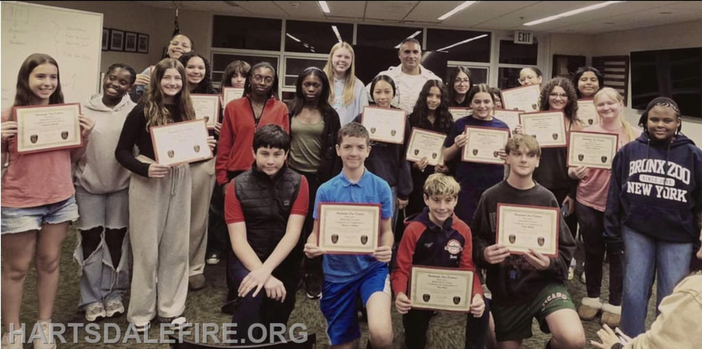 A group of students proudly displaying certificates, likely celebrating achievements or completion of a program.