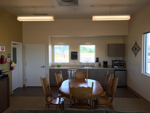 May contain: dining room, dining table, table, indoors, furniture, room, building, architecture, lamp, microwave, oven, electrical device, device, appliance, chair, handbag, bag, accessories, kitchen, interior design, sink faucet, and sink