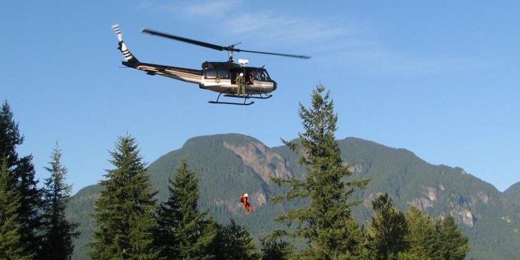 Photo of a helicopter sky lifting a person