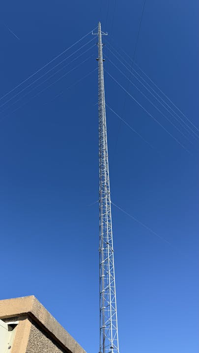 A tall communication tower extending into a clear blue sky.