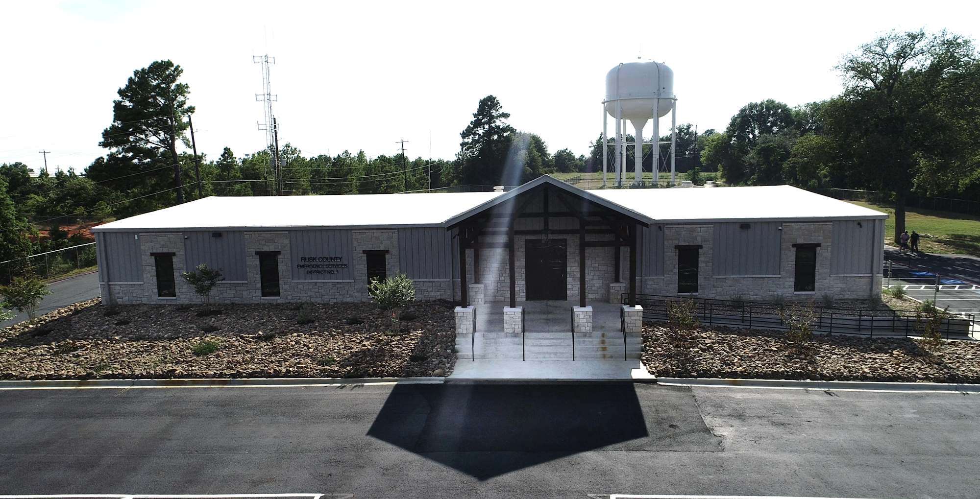 A building labeled "Rusk County Emergency Services" with a water tower and trees in the background.