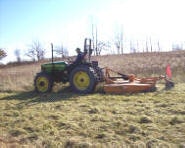 A tractor with attached agricultural equipment in a field.