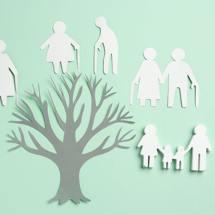 Paper cutouts of a tree with family figures around it, depicting different generations.