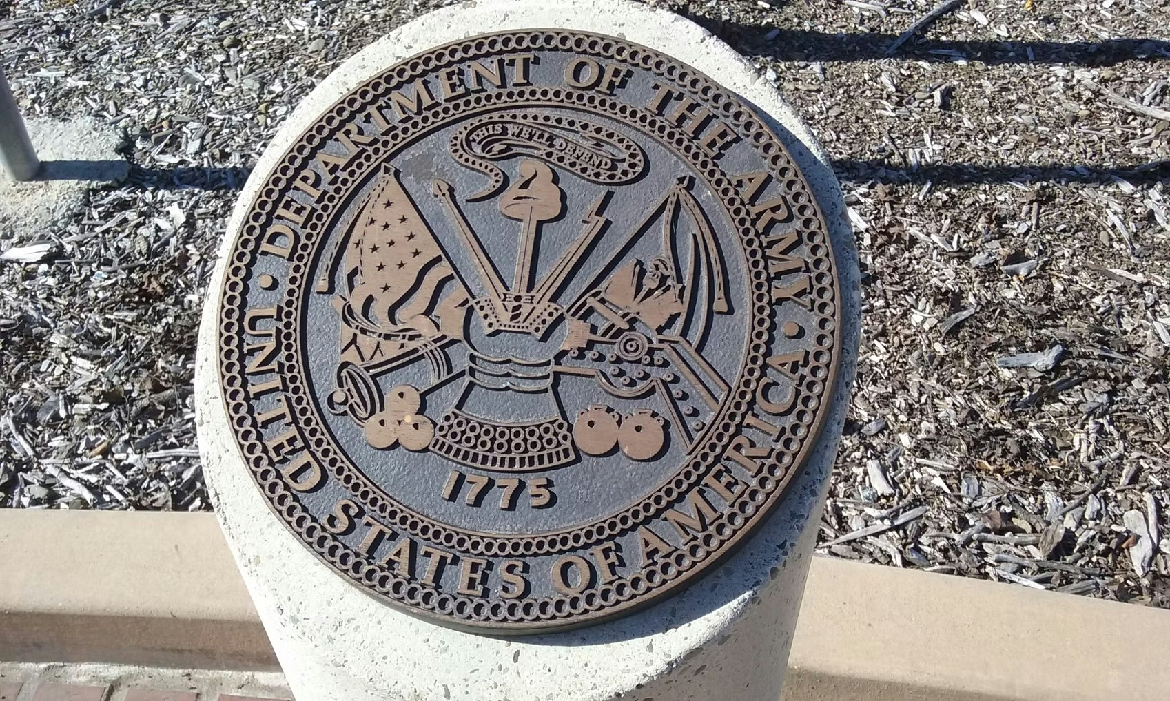 The image shows a seal for the U.S. Department of the Army, featuring symbols representing military strength and history.
