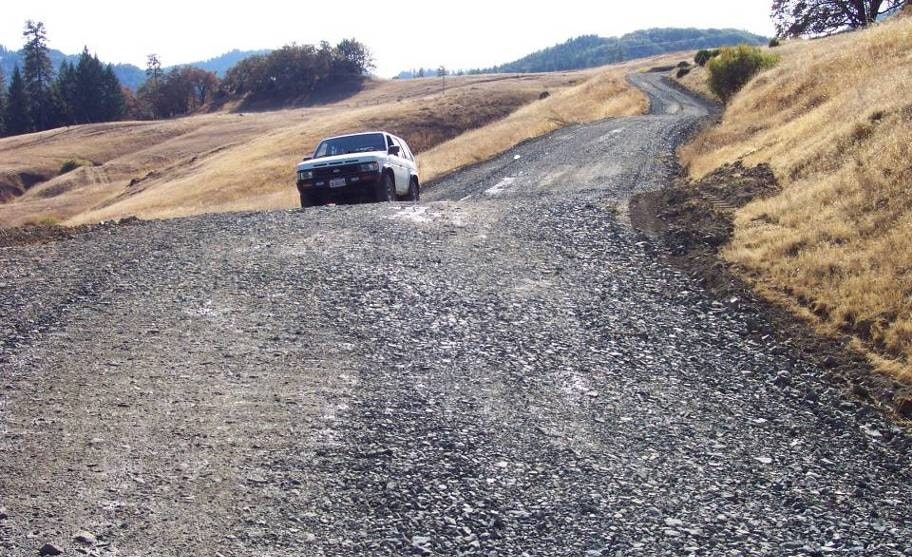 May contain: gravel, road, dirt road, car, transportation, vehicle, and automobile