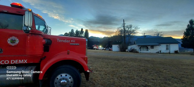 Red fire truck with "Tender 452" on the side, evening sky, houses, watermark "Shot with my Galaxy A71 5G999999".