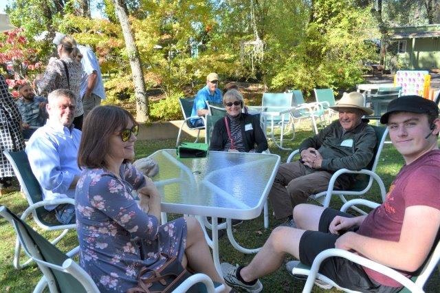 May contain: chair, furniture, yard, outdoors, nature, person, human, clothing, apparel, grass, plant, backyard, and table