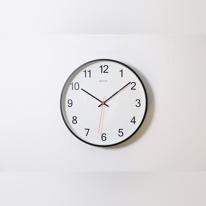 A wall clock showing time, with a simple, modern design.
