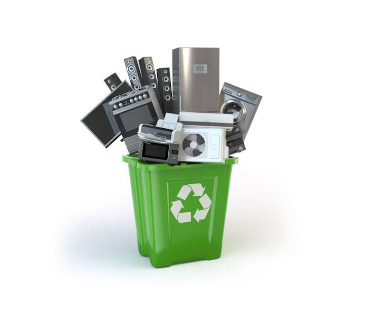 A green recycling bin overflowing with various electronic devices suggesting e-waste recycling.