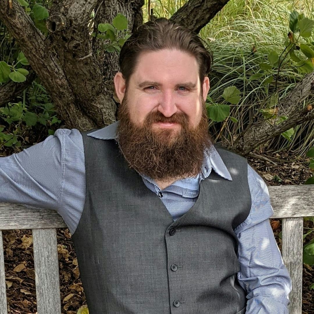 CCSD Board Member Nick Spinner Man with beard sitting outside on a bench