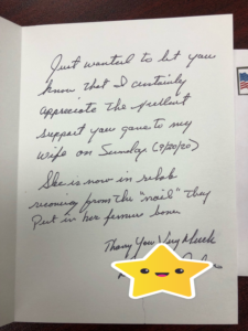 A handwritten note expressing support and thanks, with a signature at the bottom and a smiley sticker.