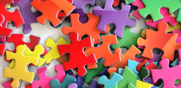 A colorful assortment of jigsaw puzzle pieces scattered across a surface.