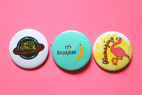 Three colorful badges on a pink background: "I need space" with a planet, "It's bananas" with a banana, and "flamazing" with a flamingo.