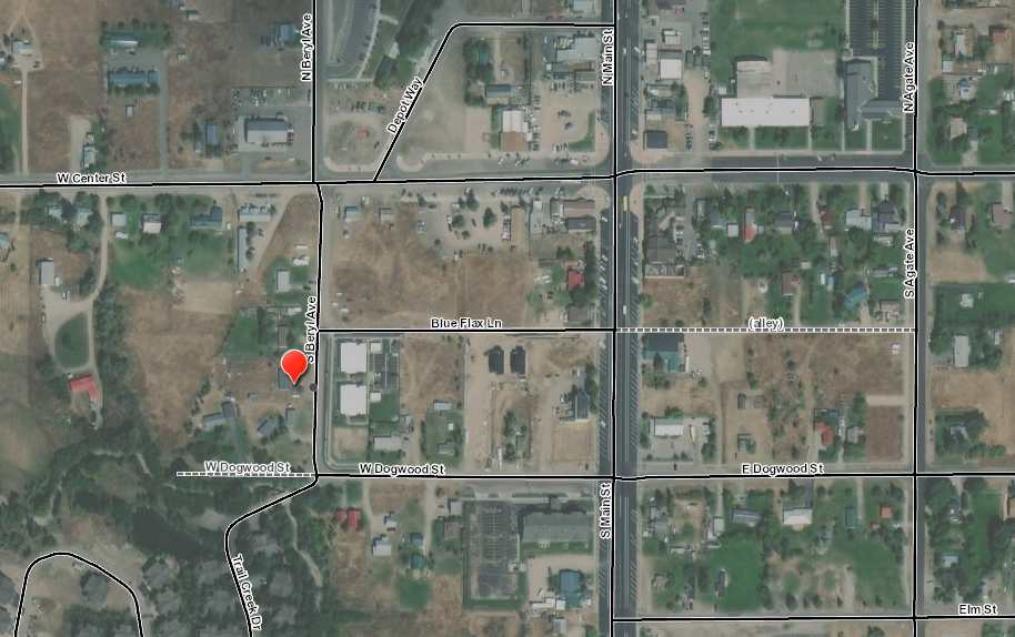 A satellite view of an urban area with streets, buildings, and marked location.